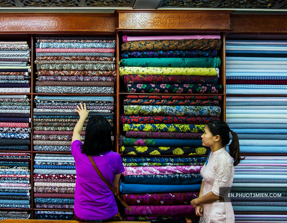 Choosing fabric at a tailor shop in Hoi An